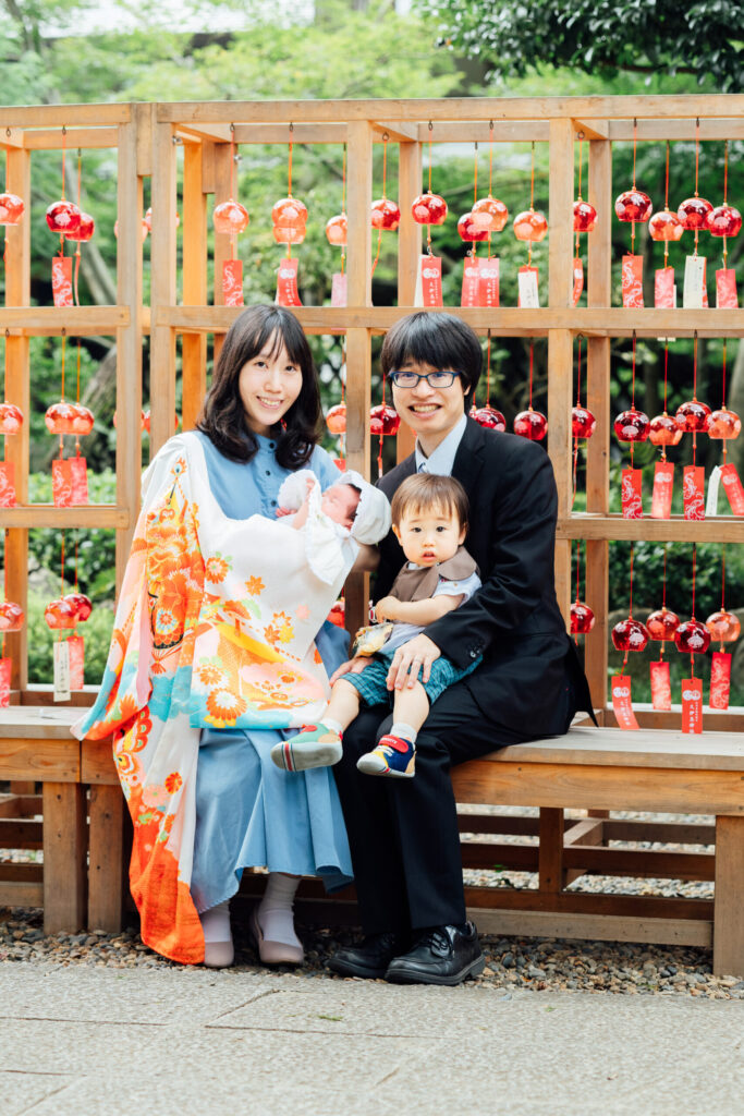 風鈴の下のベンチで家族四人のお宮参り写真